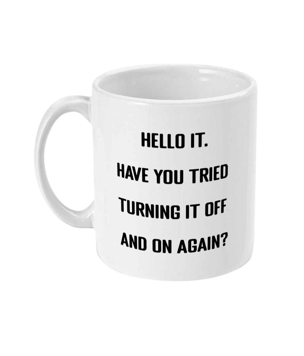 A glossy white 11oz mug with the words 'Hello IT. Have you tried turning it off and on again?' printed in the centre of the mug in simple black block font. The mug is placed in front of a white background.