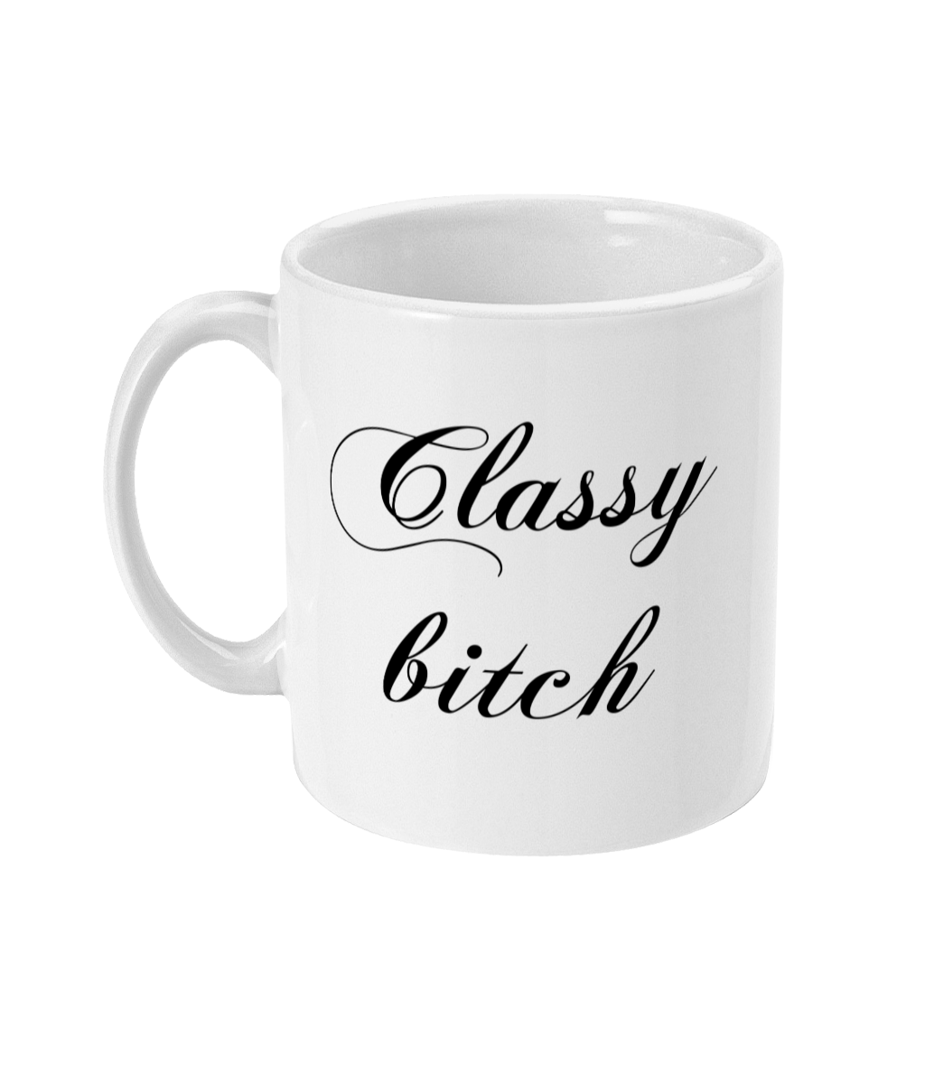 A 11oz glossy white mug with the words 'Classy bitch' in large cursive black font placed in its centre. The mug is placed against a plain white background. 