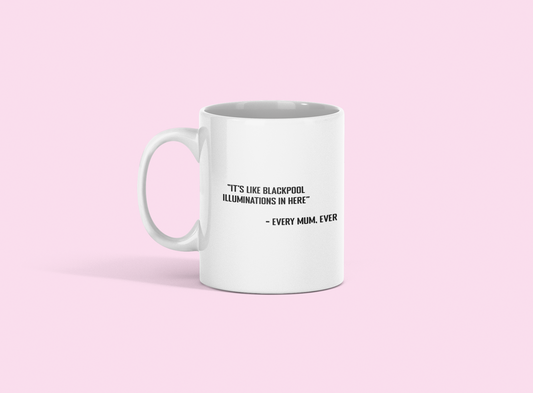 A glossy white 11oz mug with the statement 'it's like Blackpool illuminations in here - every mum, ever' printed on it's centre. The mug is placed against a pale pink background. 